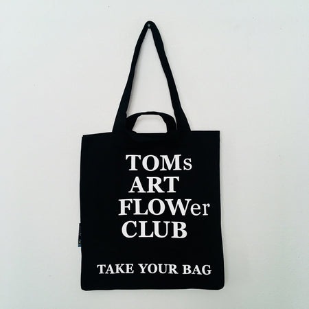 Black TAKE YOUR BAG made of 100% organic cotton, NEUTRAL® and FAIRTRADE® certified with white TOMs ART FLOWer CLUB design