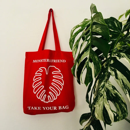 Red TAKE YOUR BAG with white MONSTERA FRIEND design by TOMs FLOWer CLUB made of 100% organic cotton, EarthPositive® certified, various colours, Swiss designed, premium quality, world wide shipping.