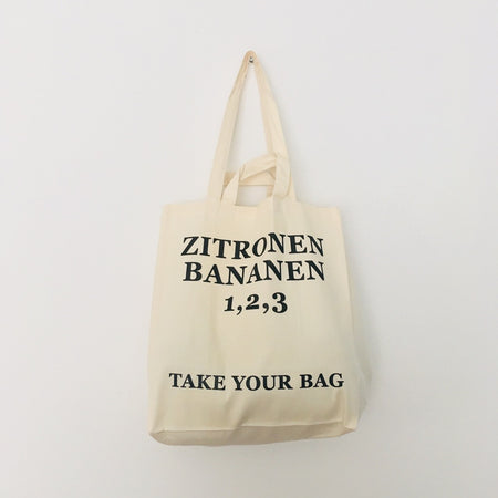 Beige TAKE YOUR BAG made of 100% organic cotton, NEUTRAL® and FAIRTRADE® certified with black ZITRONEN, BANANEN, 1, 2, 3 design.