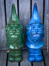 Two garden gnomes, one green and one blue, against a wooden background.
