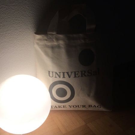 Beige TAKE YOUR BAG mit schwarzem UNIVERSAL Design aus 100% Bio-Baumwolle, NEUTRAL® und FAIRTRADE® zertifiziert, mit der Lampe.