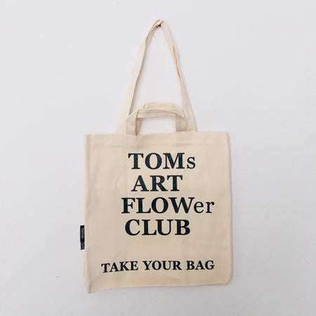 Beige TAKE YOUR BAG made of 100% organic cotton, NEUTRAL® and FAIRTRADE® certified with black TOMs ART FLOWer CLUB design.