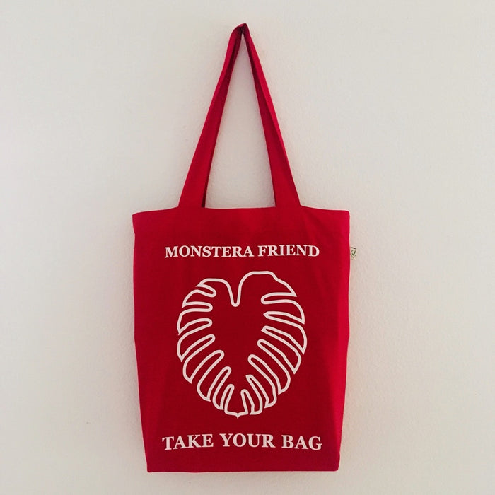 Red TAKE YOUR BAG with white MONSTERA FRIEND design by TOMs FLOWer CLUB made of 100% organic cotton, EarthPositive® certified, various colours, Swiss designed, premium quality, world wide shipping.