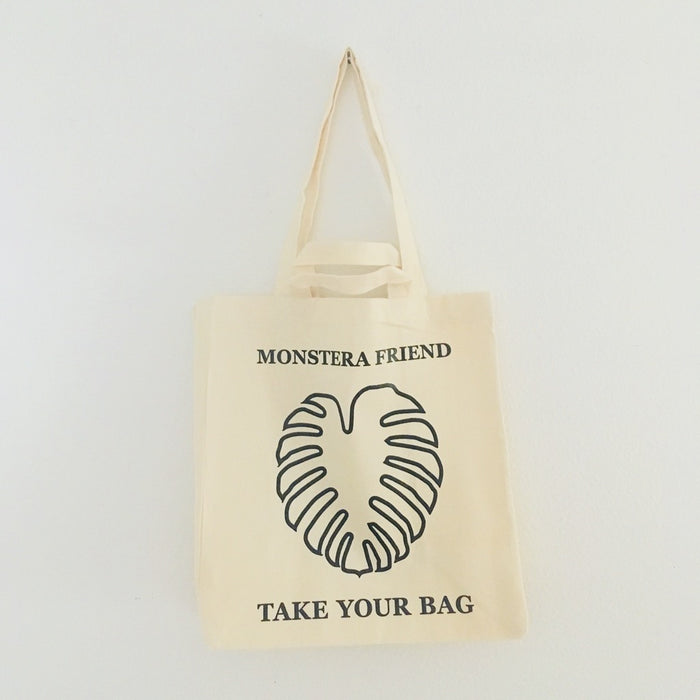 Beige TAKE YOUR BAG made of 100% organic cotton, NEUTRAL® and FAIRTRADE® certified with black MONSTERA FRIEND design, Monstera, Monstera friend, Baumwolltasche, Stofftasche, tote bag, shopping bag, TOMs FLOWer CLUB, TAKE YOUR BAG, organic cotton, bio Baumwolle. Einkaufen, Einkaufstasche 