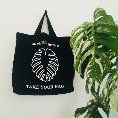 Schwarze TAKE YOUR BAG mit weißem MONSTERA FRIEND Design aus 100% Bio-Baumwolle, NEUTRAL® und FAIRTRADE® zertifiziert.
