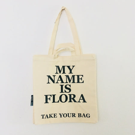 Beige TAKE YOUR BAG made of 100% organic cotton, NEUTRAL® and FAIRTRADE® certified with black MY NAME IS FLORA design.