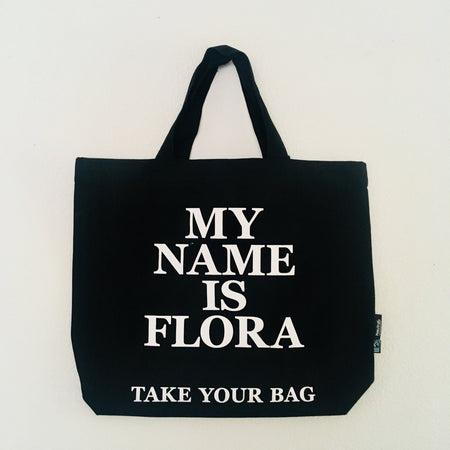 Black TAKE YOUR BAG with white MY NAME IS FLORA design made of 100% organic cotton, NEUTRAL® and FAIRTRADE® certified.
