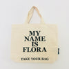 Beige TAKE YOUR BAG with black MY NAME IS FLORA design made of 100% organic cotton, NEUTRAL® and FAIRTRADE® certified.