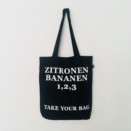 Black TAKE YOUR BAG with white ZITRONEN, BANANEN, 1,2,3 design by TOMs FLOWer CLUB made of 100% organic cotton, EarthPositive® certified, various colours, Swiss designed, premium quality, world wide shipping.