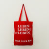 Red TAKE YOUR BAG with white LEBEN LEBENd erLEBEN design by TOMs FLOWer CLUB made of 100% organic cotton, EarthPositive® certified, various colours, Swiss designed, premium quality, world wide shipping.