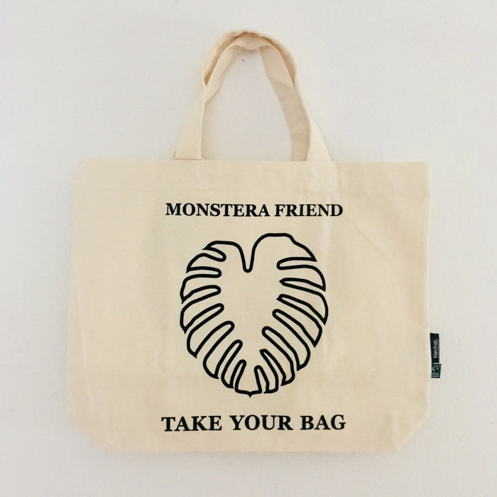 Beige TAKE YOUR BAG with black MONSTERA FRIEND design made of 100% organic cotton, NEUTRAL® and FAIRTRADE® certified, Monstera, Monstera friend, Baumwolltasche, Stofftasche, tote bag, shopping bag, TOMs FLOWer CLUB, TAKE YOUR BAG, organic cotton, bio Baumwolle. Einkaufen, Einkaufstasche 
