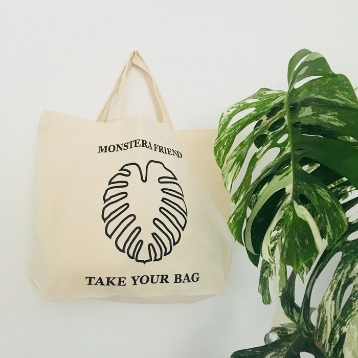 Beige TAKE YOUR BAG mit schwarzem MONSTERA FRIEND Design aus 100% Bio-Baumwolle, NEUTRAL® und FAIRTRADE® zertifiziert mit der Monstera Pflanze, Monstera, Monstera friend, Baumwolltasche, Stofftasche, tote bag, shopping bag, TOMs FLOWer CLUB, TAKE YOUR BAG, organic cotton, bio Baumwolle. Einkaufen, Einkaufstasche 