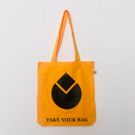 Gold-coloured cotton tote bag with a black water drop design and the text 'TAKE YOUR BAG' printed on the bottom.
