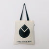 A beige cotton bag with a black handle featuring a black geometric water drop design and the text 'TAKE YOUR BAG' on the front.