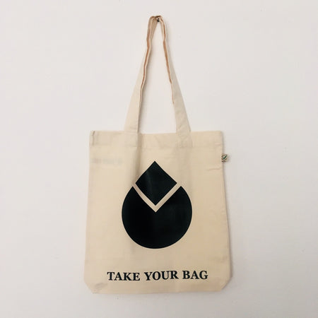 A beige canvas tote bag with a black water drop design and the text 'TAKE YOUR BAG' printed on the front.