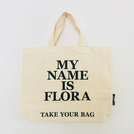 Beige TAKE YOUR BAG with black MY NAME IS FLORA design made of 100% organic cotton, NEUTRAL® and FAIRTRADE® certified.