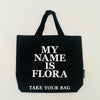 Black TAKE YOUR BAG with white MY NAME IS FLORA design made of 100% organic cotton, NEUTRAL® and FAIRTRADE® certified.